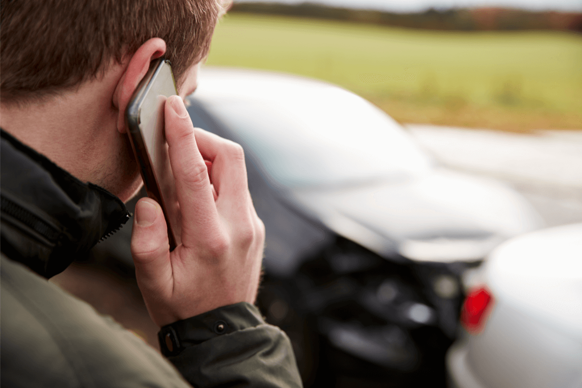 Man on a phone after a car accident. Can you fight an at fault car accident.